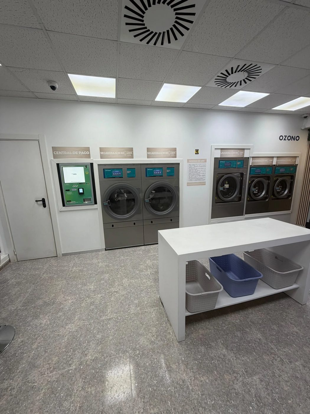 Interior del local con la central de pago y la mesa para doblar la ropa